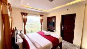 a bedroom with a bed and a large window at Hotel Hill Edge in Kodaikānāl