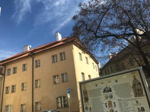 um grande edifício com uma placa em frente em Apartments & Restaurant Tkalcovsky dvur em Praga