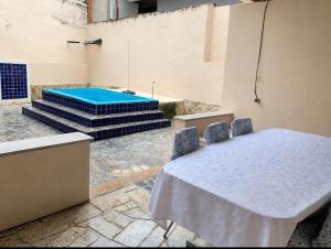 a table and chairs with a pool in a building at Casa na praia bem localizada in Marataizes