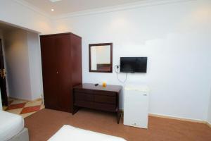 a room with a desk and a tv on a wall at فندق ربا الحجاز توصيل للحرم in Az Zahrāʼ
