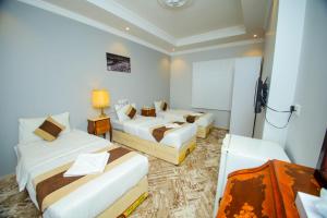 a hotel room with two beds and a television at فندق ربا الحجاز توصيل للحرم in Az Zahrāʼ +25 photos