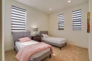 two beds in a room with windows at Private Yard & Patio! Modern Manteca Gem in Manteca