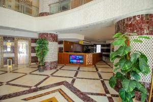 a lobby with a tv and plants in a building at فندق ربا الحجاز توصيل للحرم in Az Zahrāʼ