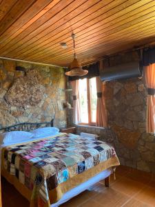 a bedroom with a bed in a stone wall at Uysallar Koy Evi in Gokceada Town