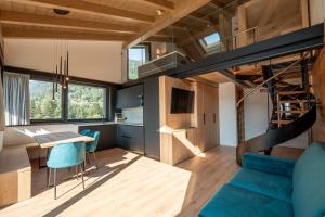 a tiny house with a staircase and a blue couch at Echo - Private Spa Apartments in Ponte di Legno