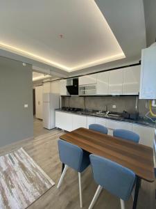 a kitchen with a wooden table and blue chairs at lizbon suit in Talas