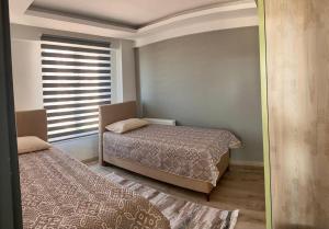 a bedroom with two beds and a window with blinds at lizbon suit in Talas