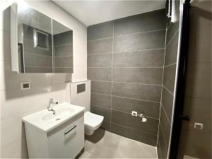 a bathroom with a sink and a toilet and a mirror at lizbon suit in Talas
