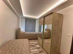 a bedroom with two beds and a large wooden cabinet at lizbon suit in Talas