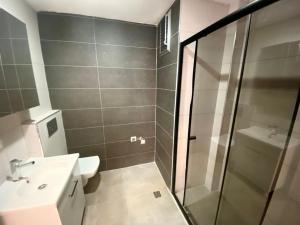 a bathroom with a shower and a toilet and a sink at lizbon suit in Talas
