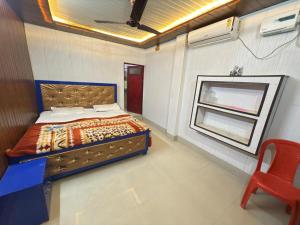 a bedroom with a bed and a window and a chair at Vaishno Atithi Bhawan in Naimishāranya