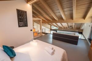 a bedroom with a large bed and a tub at Echo - Private Spa Apartments in Ponte di Legno