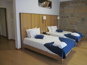 two beds in a hotel room with towels on them at Hotel Solar da Capela in Termas de Sao Pedro do Sul +51 photos