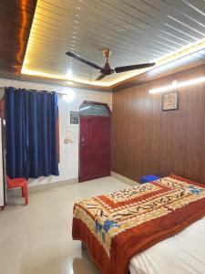 a bedroom with a bed and a ceiling fan at Vaishno Atithi Bhawan in Naimishāranya