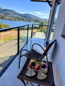 a table with two glasses of wine and fruit on a balcony at Pousada Capitólio in Capitólio +105 photos