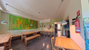 a restaurant with wooden tables and chairs and a large painting on the wall at Babelfish Hostel in Würzburg