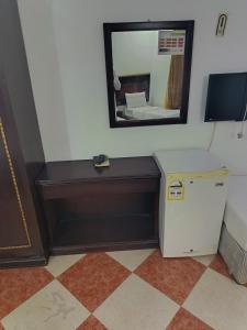 a room with a small refrigerator and a mirror at فندق ربا الحجاز توصيل للحرم in Az Zahrāʼ