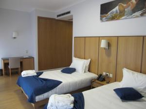 a hotel room with two beds and a telephone at Hotel Solar da Capela in Termas de Sao Pedro do Sul