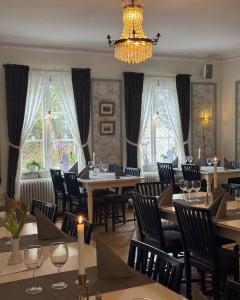 a dining room with tables and chairs and a chandelier at Wanbo Herrgård in Nedre Vanbo
