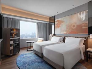 a bedroom with a large white bed and a window at Mövenpick Hotel Jakarta City Centre in Jakarta