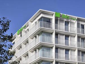a tall white building with a bus sign on it at ibis Styles Bredene in Bredene
