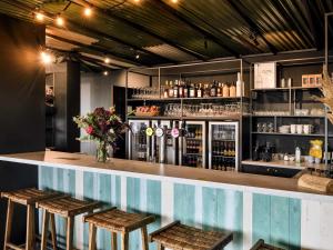 a bar with stools and a counter with drinks at ibis Styles Bredene in Bredene +28 photos