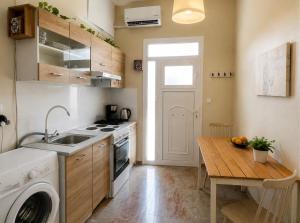 a kitchen with a washing machine and a wooden table at Okio in Petra