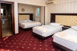 a hotel room with two beds and a bathroom at Pensiunea ORIENT in Brăila
