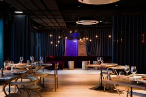 ein Esszimmer mit Tischen, Stühlen und einem Sofa in der Unterkunft Docas Hotel Lisbon in Lissabon