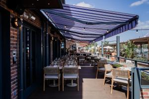 ein Restaurant mit Tischen und Stühlen auf einem Balkon in der Unterkunft Docas Hotel Lisbon in Lissabon
