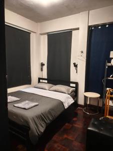 a bedroom with a bed and two large windows at Dreamcatcher Bangkok in Bangkok