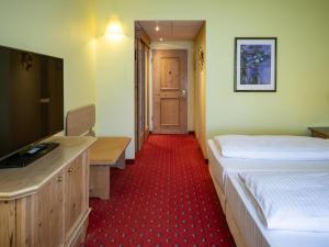 オーバーディングにあるAtomis Hotel Munich Airport by Mercureのベッド2台と薄型テレビのある部屋