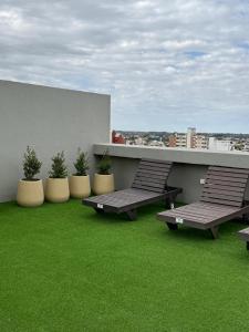 a balcony with two benches and green grass at luxury apart 1 in Villa María