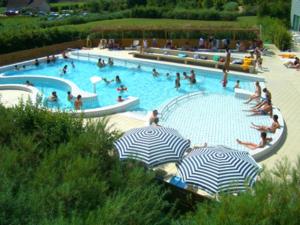 a large swimming pool with people in it with umbrellas at Le loft de l'entrepote in Argenton-sur-Creuse
