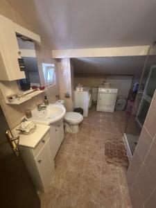 a bathroom with a toilet and a sink and a shower at Къща за гости Амбър in Burgas +42 photos