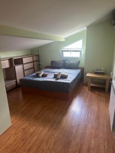 a bedroom with a bed and a wooden floor at Къща за гости Амбър in Burgas
