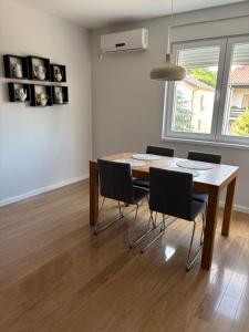 a dining room with a wooden table and chairs at Apartman Vila&Vera in Sremska Mitrovica +12 photos