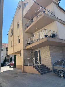 a apartment building with a staircase and a balcony at Apartman Vila&Vera in Sremska Mitrovica