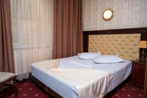 a bedroom with a large bed with a white bedspread at Pensiunea ORIENT in Brăila