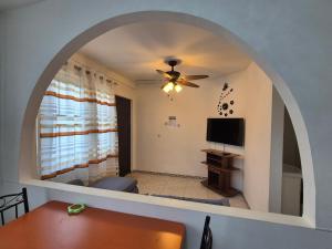 a living room with a ceiling fan and a tv at Sterappel Sun Stay in Paramaribo