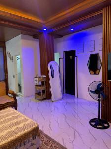 a bedroom with a purple room with a bed and a tv at LALEAH Transient House in Cotabato