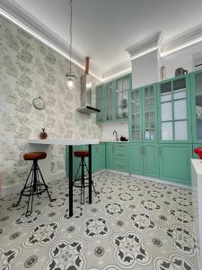 a kitchen with green cabinets and a counter with stools at Apartamento El Mar Azul 5 in Torremolinos