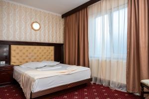 a hotel room with a bed and a window at Pensiunea ORIENT in Brăila +16 photos