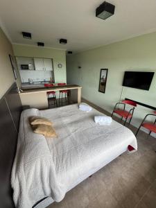 a bedroom with a large bed and a kitchen at Río Victoria in Victoria
