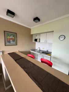 a kitchen with a large wooden table with red chairs at Río Victoria in Victoria +3 photos