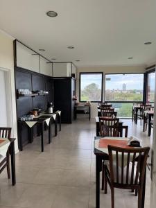 a restaurant with wooden tables and chairs and windows at Río Victoria in Victoria