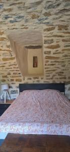 ein Schlafzimmer mit einem Bett vor einer Steinwand in der Unterkunft Authentique-CAVE Les Assions in Les Assions