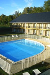 une grande piscine en face d'un bâtiment dans l'établissement Adonis Hauts De Honfleur, à Équemauville