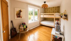 a small room with a bunk bed and a window at Chalet avec spa et lac privé in Saint Come