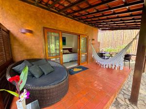 a room with a bed and a hammock on a patio at Pousada do Vale in Fernando de Noronha